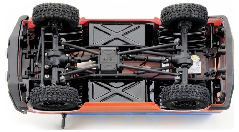 Spielzeugauto von unten mit sichtbarer Aufhängung und großen Reifen, zeigt technische Details des Fahrwerks.