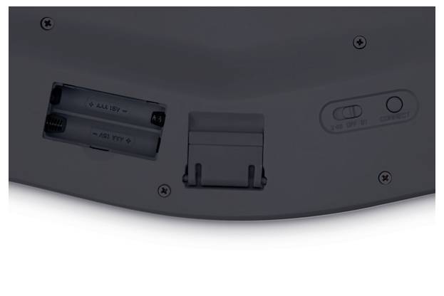 Rückseite eines Geräts mit Batteriefach für zwei AA-Batterien und Schalter für An/Aus/Bluetooth-Verbindung.