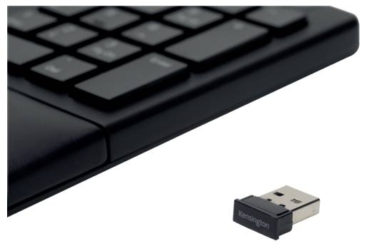 Eine schwarze Computer-Tastatur liegt neben einem USB-Adapter, der mit 'Kensington' beschriftet ist.