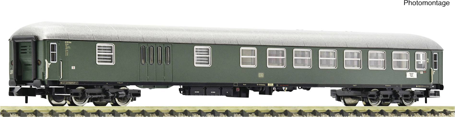 Ein grüner Modelleisenbahn-Wagen auf einem Gleis in Seitenansicht.