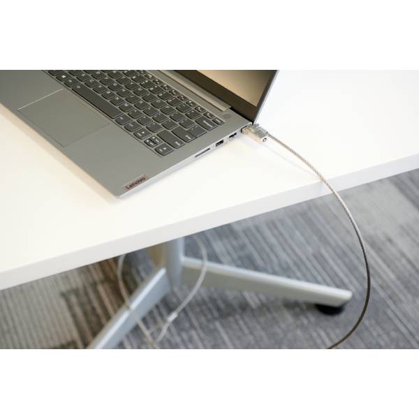 Ein Laptop liegt auf einem Tisch mit einem angeschlossenen Sicherheitsschloss, das an der Tischkante befestigt ist.