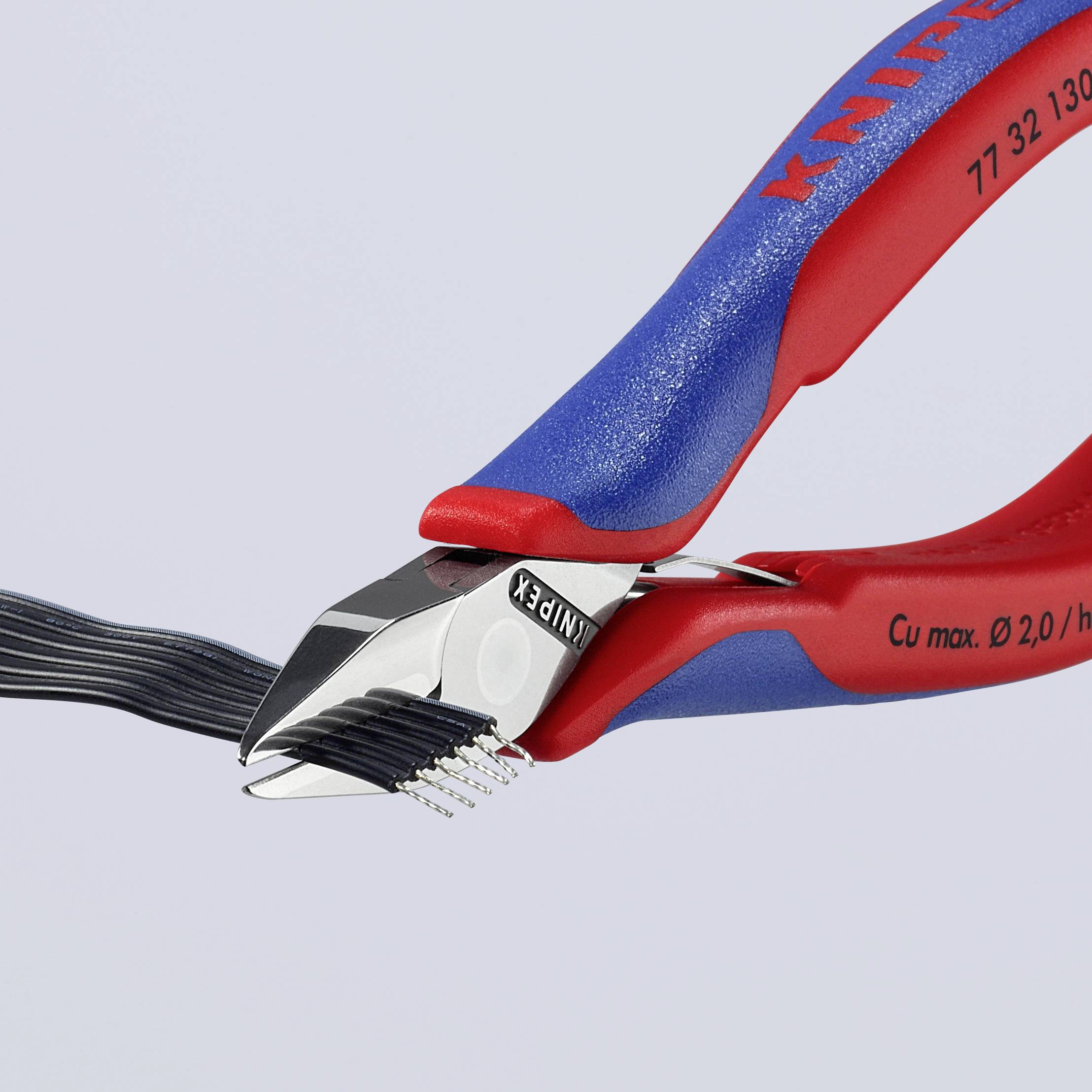 Kabelschneider schneidet mehrere schwarze Kabel, roter und blauer Griff, Detailaufnahme eines Werkzeugs in Aktion.