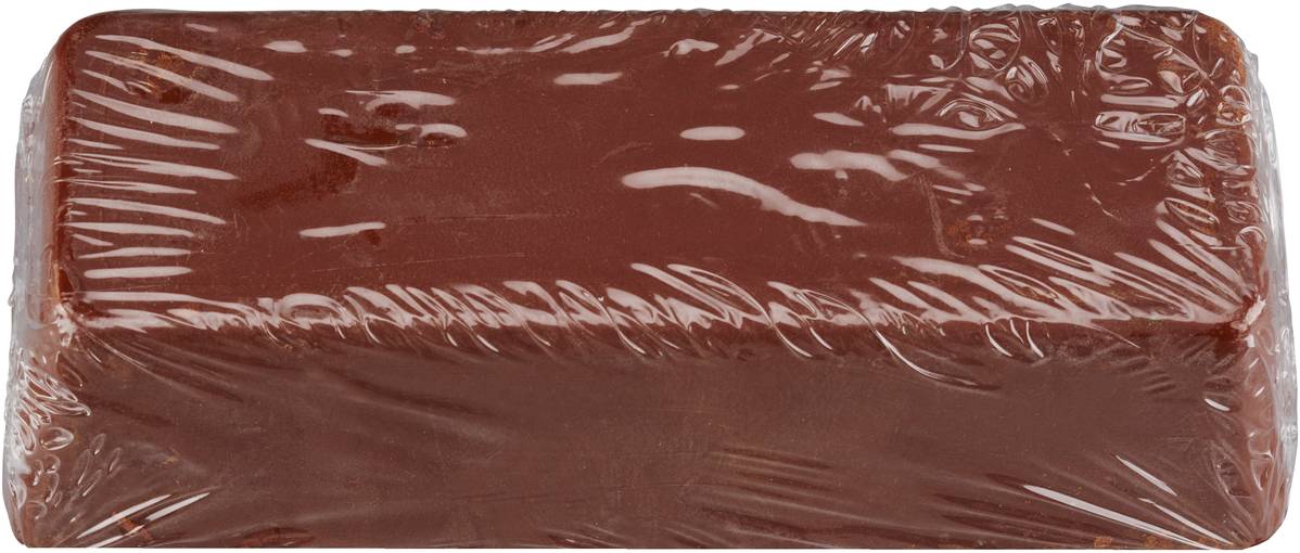 Ein rechteckiger Klotz aus rötlich-brauner Modellierknete, in transparenter Plastikfolie verpackt, auf weißem Hintergrund.