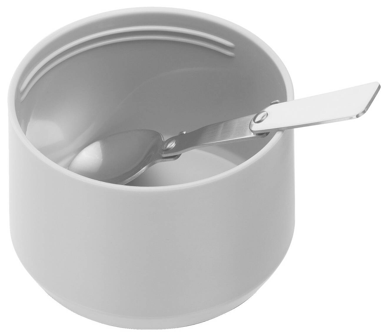 Weiße, runde Schüssel mit Metalllöffel darin, auf einer Oberfläche stehend.