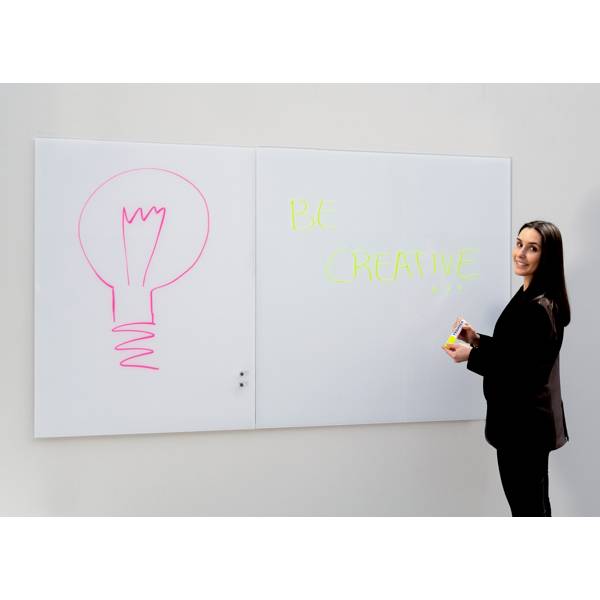 Eine Frau steht vor einem Whiteboard mit der Aufschrift 'Be Creative' und einer Zeichnung einer Glühbirne.