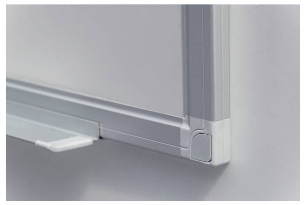 Nahaufnahme einer Ecke eines Whiteboards mit silbernem Rahmen. Der Rand hat eine abgerundete, schützende Abdeckung.