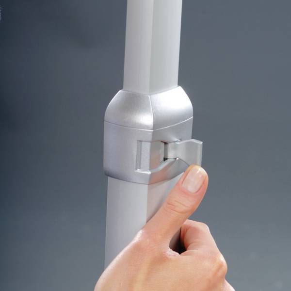 Eine Hand hält den Klemmbügel an einem Metallrohr fest.