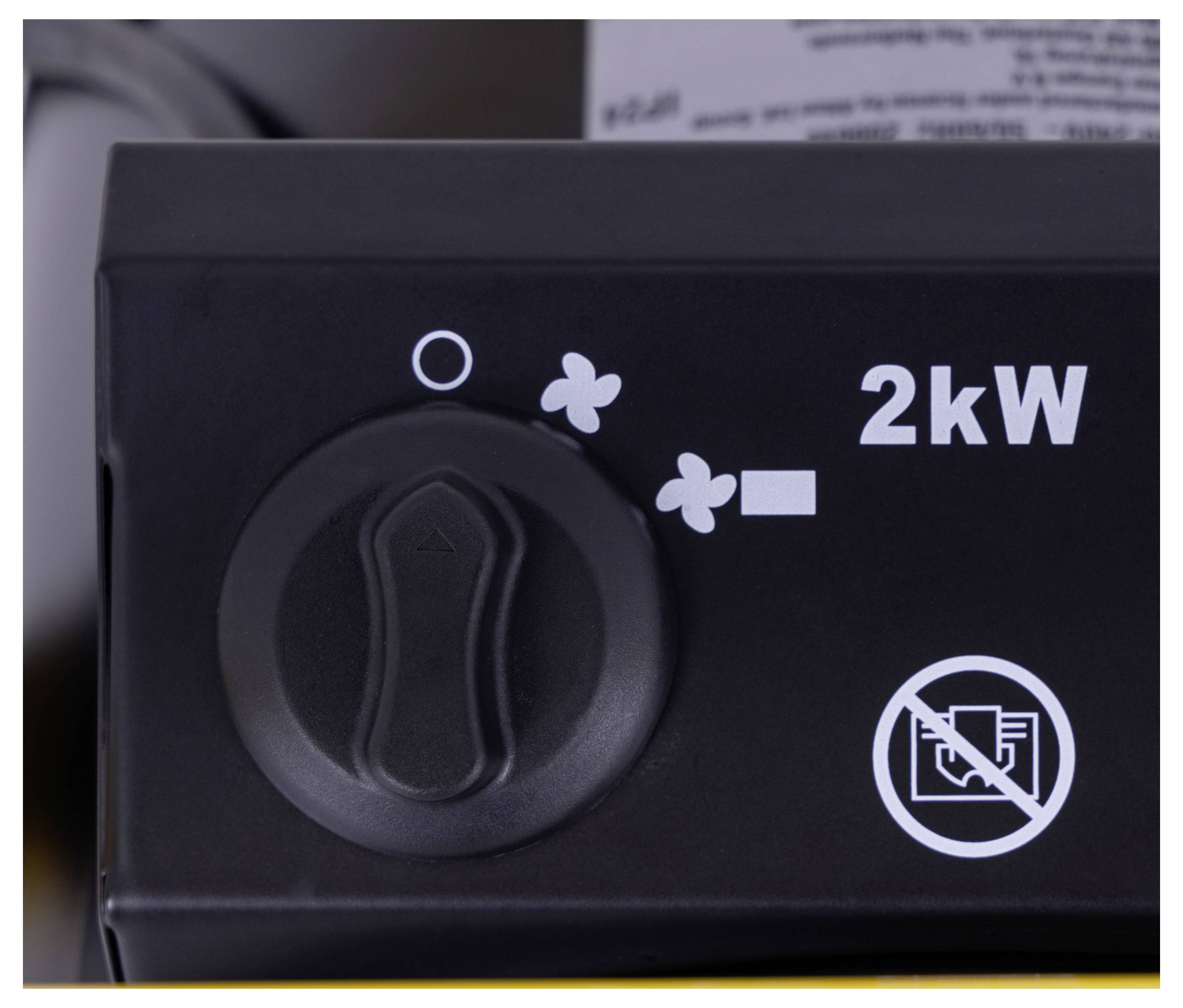 „Nahaufnahme eines schwarzen Bedienfelds mit einem Drehregler und Markierungen, die eine 2-kW-Leistungseinstellung und ein Ventilator-Symbol zeigen. Kein Rauchverbotsschild sichtbar.