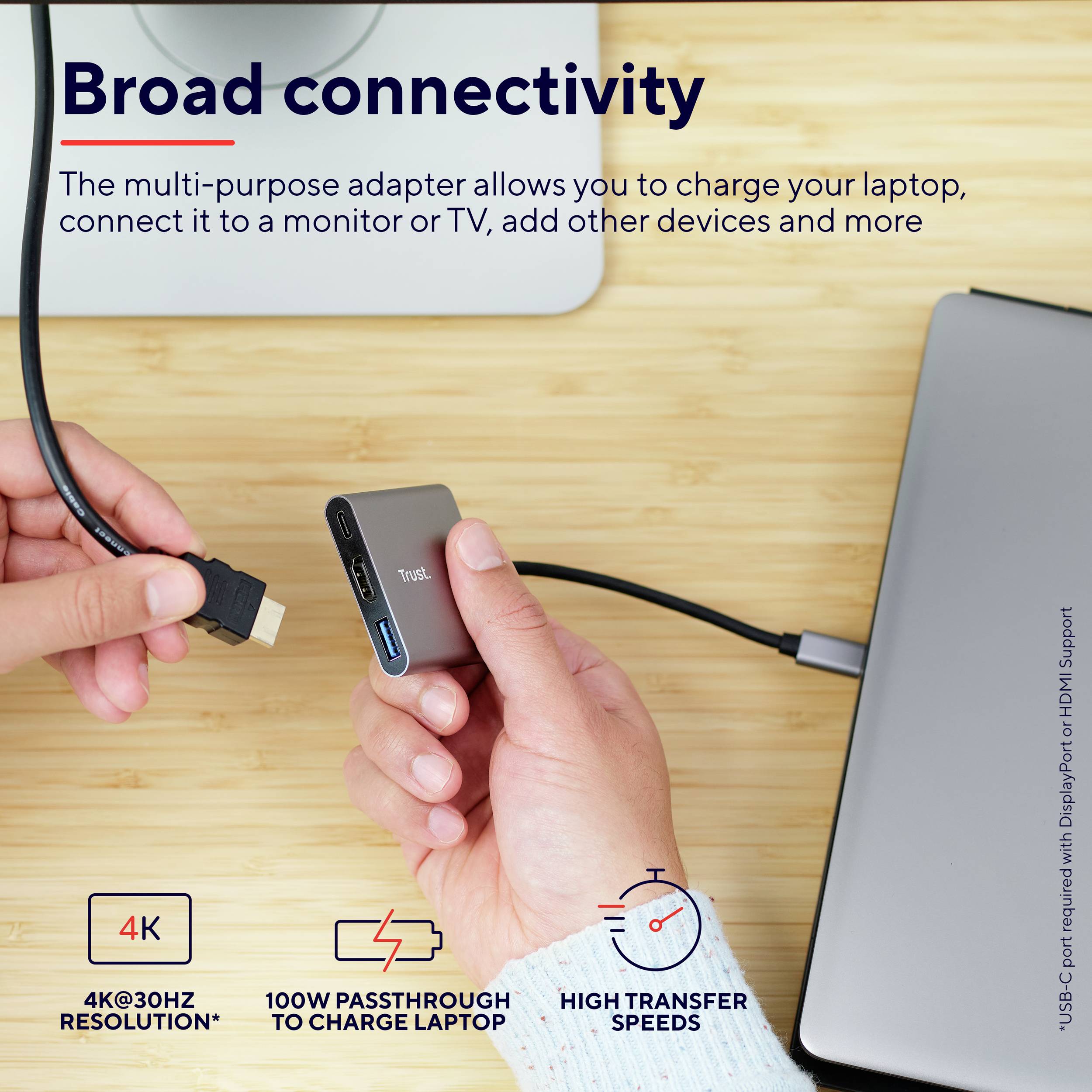 Ein Adapter verbindet ein Laptop mit einem Kabel. Text: 'Broad connectivity' und Info zu 4K 30Hz, 100W Pass-Through, hohe Übertragungsgeschwindigkeit.
