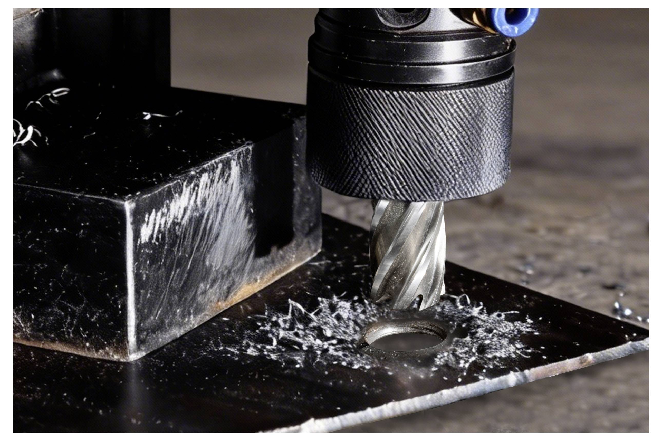 Ein Metallbohrer schneidet durch ein Metallstück und erzeugt dabei Metallspäne um das Loch herum.