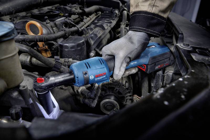 Eine Person repariert einen Autoteil mit einem blauen Bosch Elektrogerät im Motorraum eines Fahrzeugs.