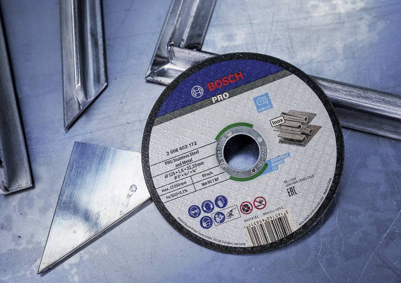 Eine Bosch PRO Trennscheibe liegt auf einer Metalloberfläche, umgeben von Metallstücken. Die Scheibe ist für Stahl und Metall geeignet.