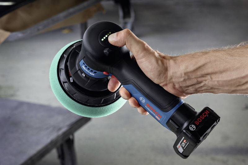 Akkupuffer von Bosch mit blau-grünem Scheibe wird in der Hand gehalten, bereit für den Einsatz beim Polieren von Oberflächen.