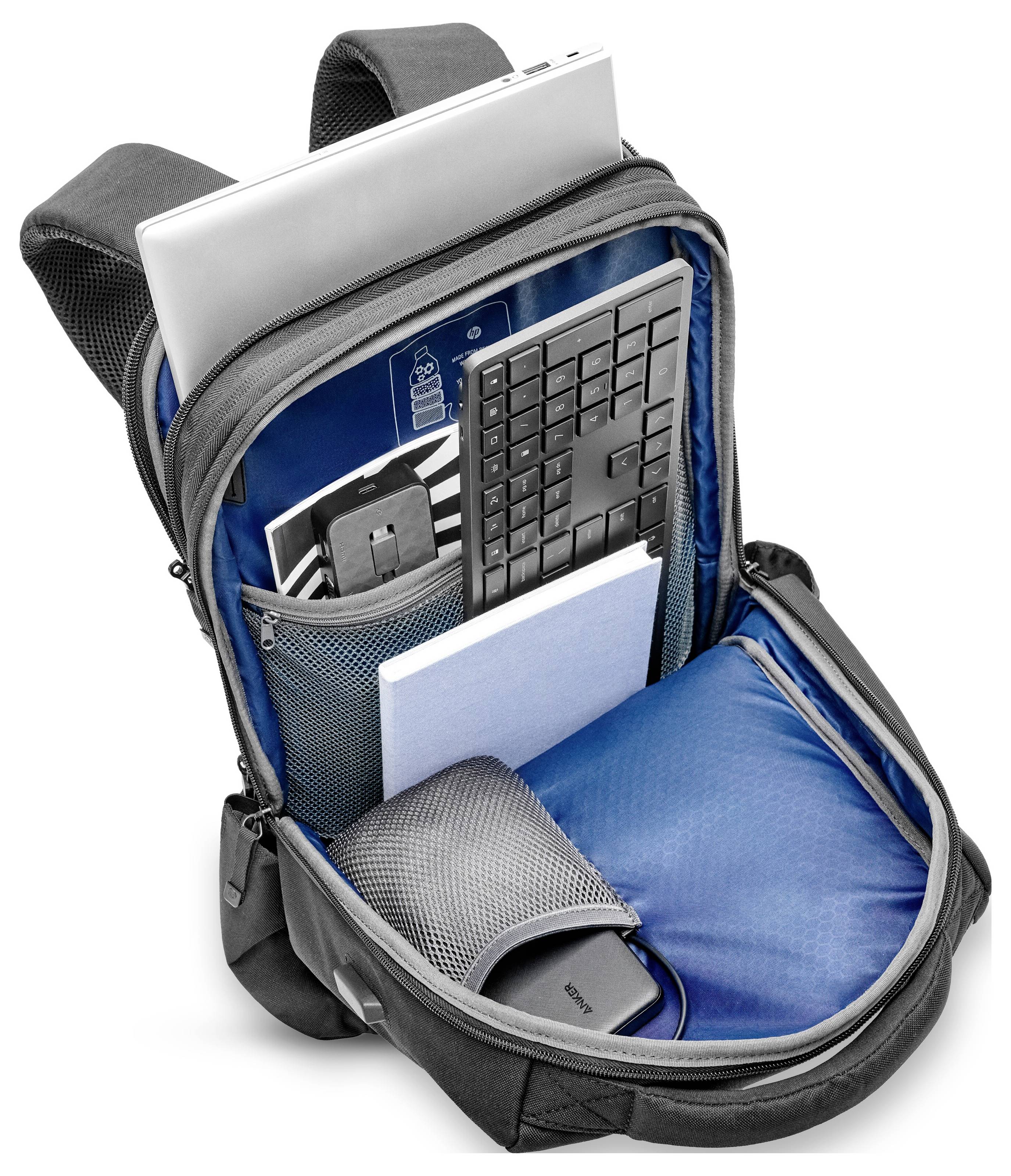 Ein geöffneter Rucksack mit Laptop, Tastatur, Notizbuch und Kopfhörern im Inneren, zeigt Stauraum und Organisation für Technikzubehör.