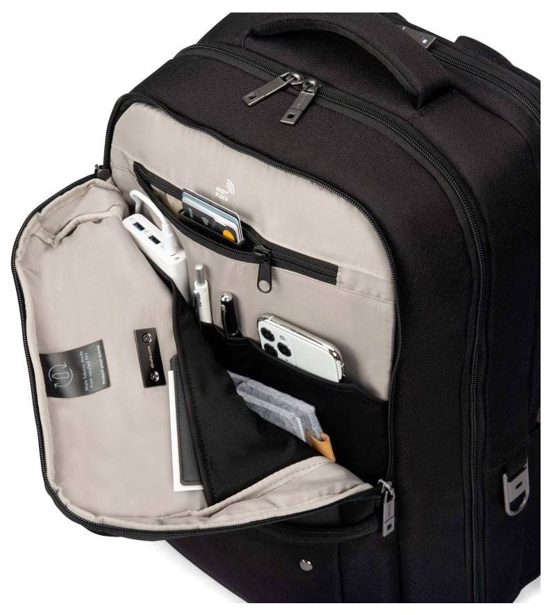 Schwarzer Rucksack mit geöffneter Klappe, zeigt Taschen für Smartphone, Stifte und andere kleine Gegenstände.