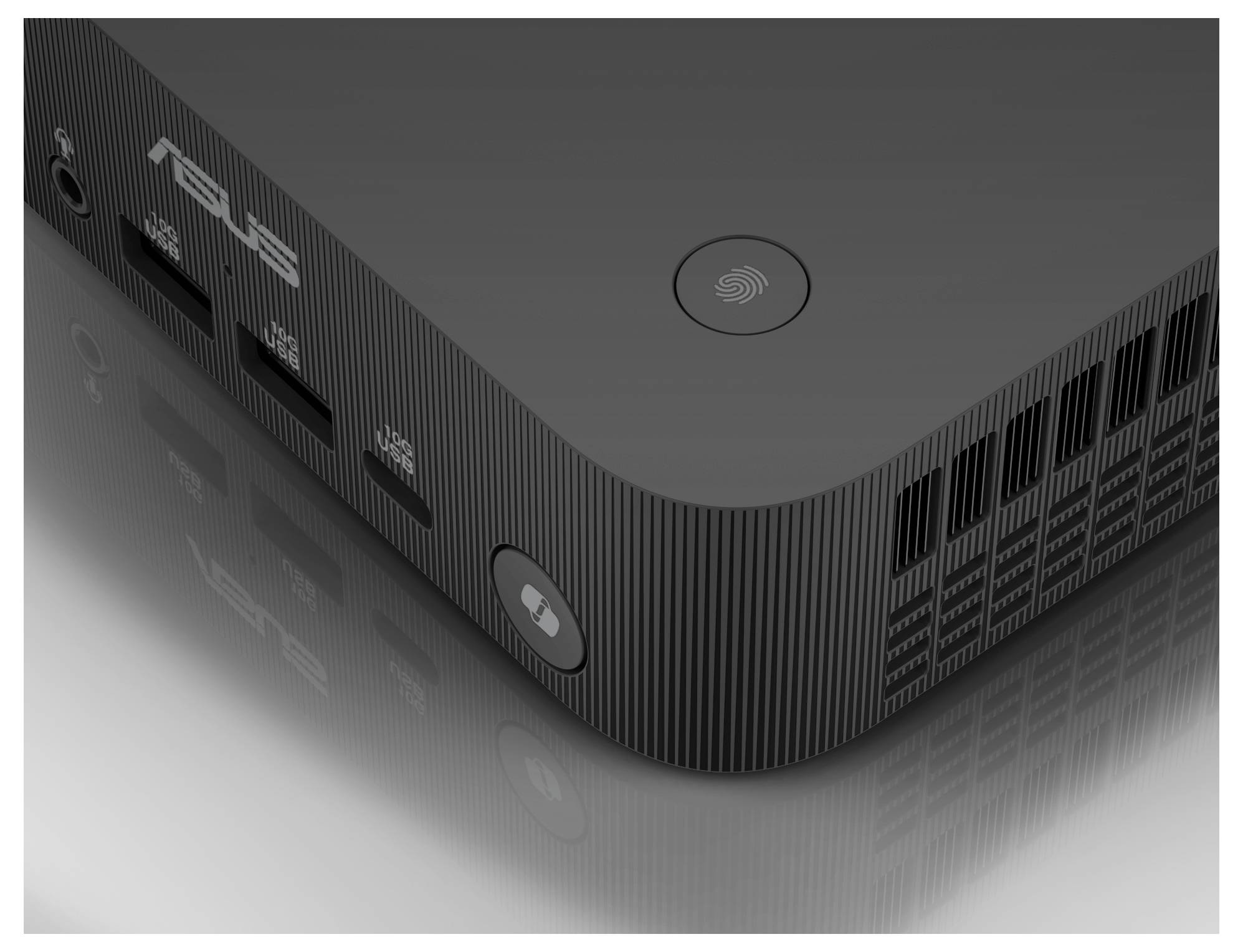 Ein schwarzer ASUS Mini-PC mit Firmenlogo, USB-Anschlüssen und Lüftungsschlitzen, auf einer reflektierenden Oberfläche.