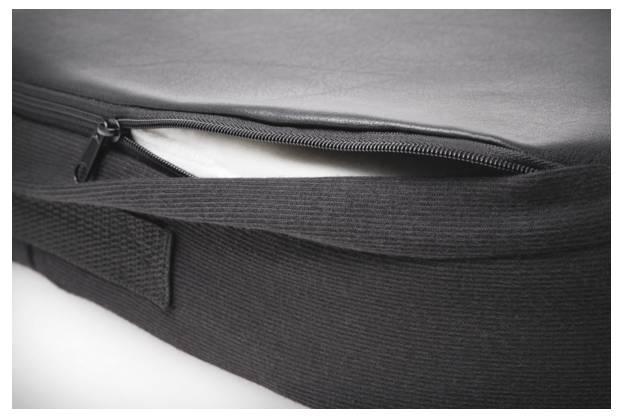 Die Abbildung zeigt eine teilweise geöffnete schwarze Tasche mit einem Reißverschluss, die einen weißen Gegenstand darin offenbart.