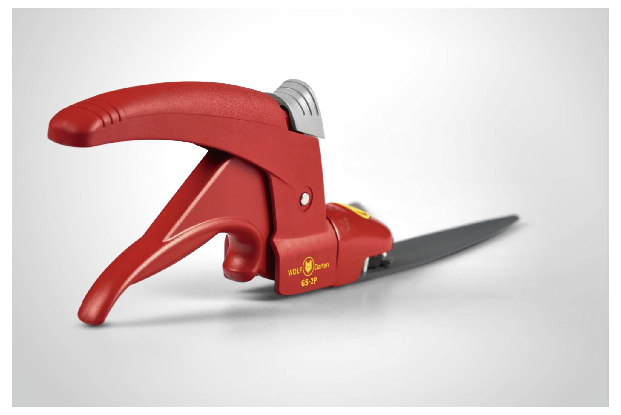 Rote Grasschere mit ergonomischem Griff und silberner Klinge, auf einer hellen Oberfläche liegend.