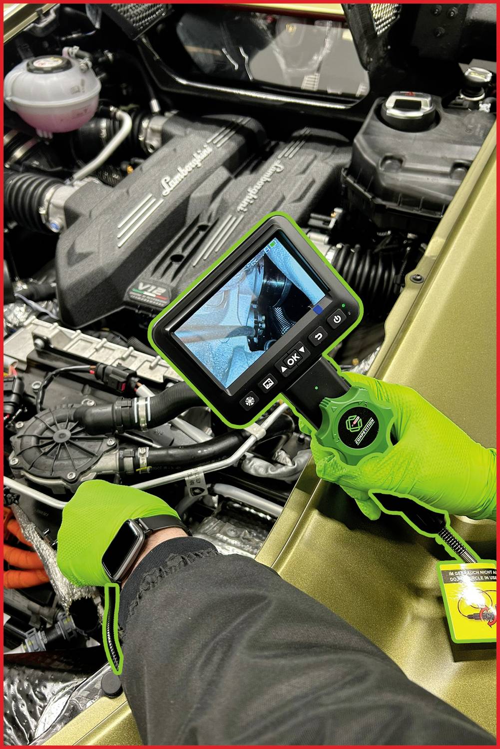 Person überprüft mit Endoskop-Kamera einen Automotor, Kamera zeigt internes Bild. Konzentriert sich auf detaillierte Inspektion.