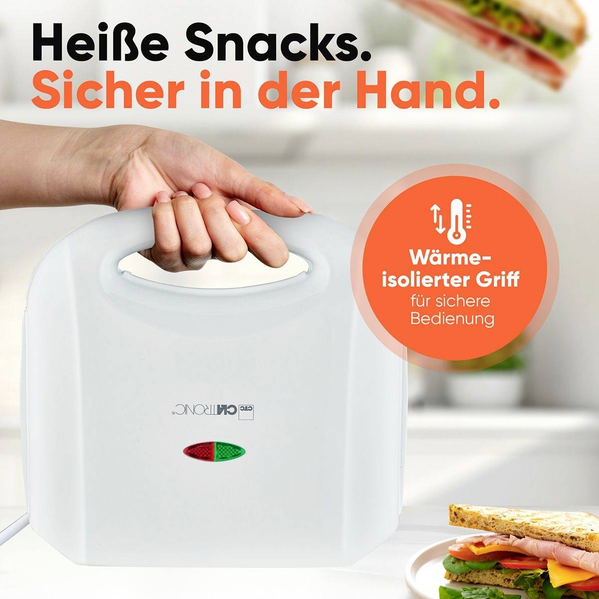 Ein Sandwichmaker mit isoliertem Griff, gehalten von einer Hand. Text: 'Heiße Snacks. Sicher in der Hand.' Sandwich im Vordergrund.