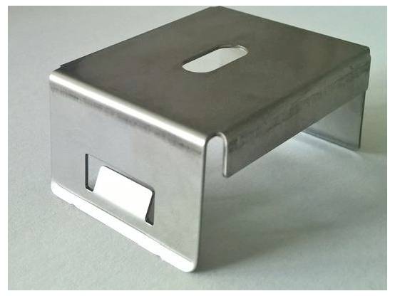 Ein kleiner, rechteckiger Metallständer mit einem ovalen Ausschnitt auf der Oberseite, geeignet zur Unterstützung oder Erhöhung von Objekten.