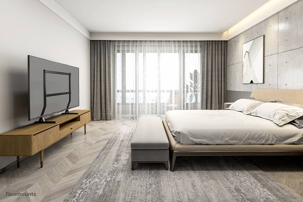 Ein modernes Schlafzimmer mit einem großen Bett, einem hölzernen TV-Schrank und einem Flachbildfernseher. Ein großes Fenster bietet Licht.