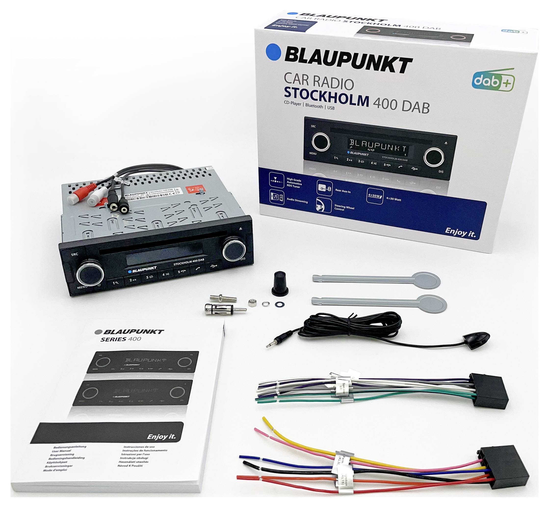 Blaupunkt Autoradio Stockholm 400 DAB mit Zubehör, einschließlich Kabel, Anleitung und Montagewerkzeug, auf einem Tisch ausgelegt.