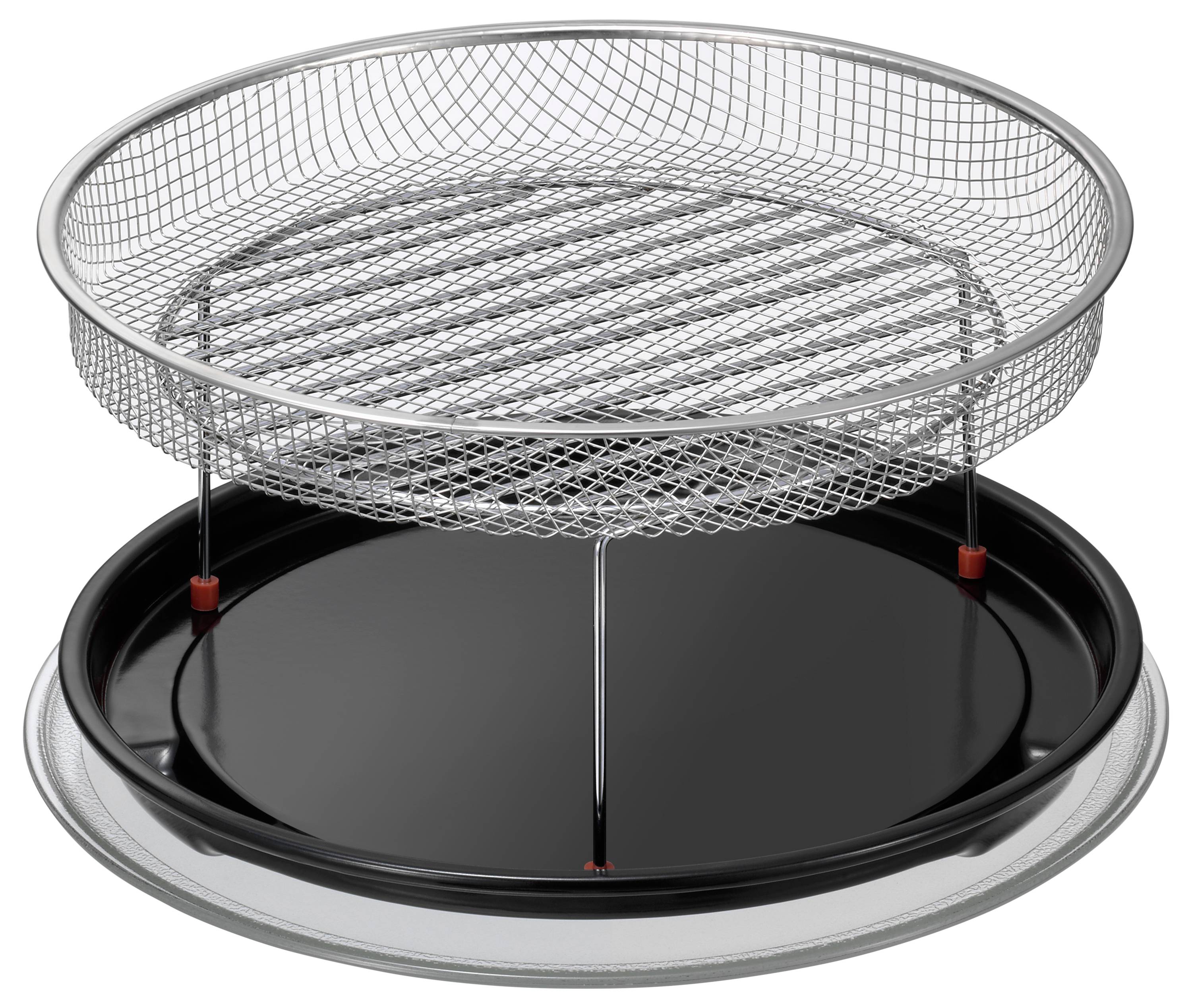 Ein runder, silberner Metallgrill mit einem flachen Gitterrost und einem schwarzen, abnehmbaren Boden, auf einem Tisch positioniert.