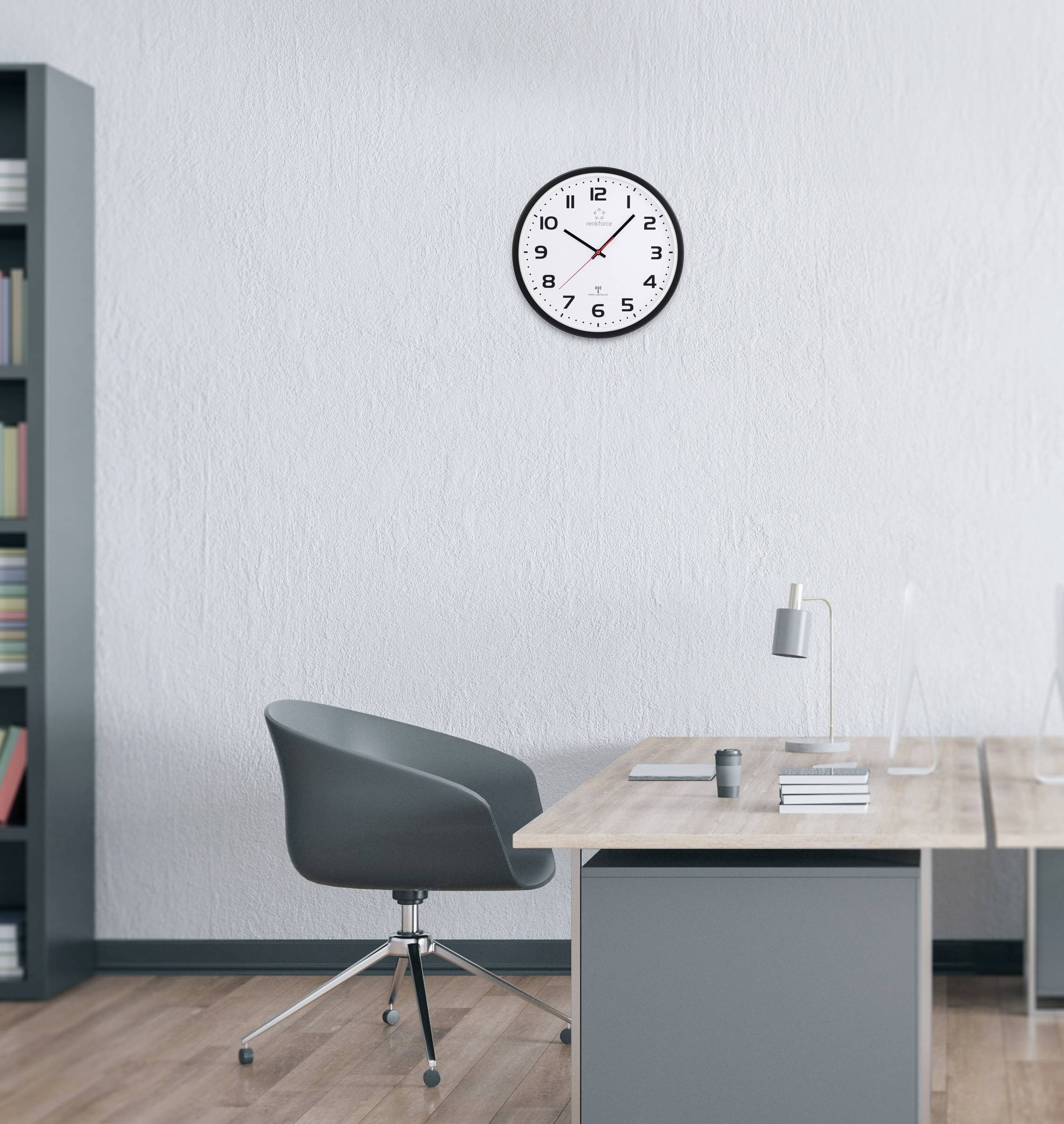 Eine Büroeinrichtung mit einem grauen Stuhl, einem Holzschreibtisch, einer Lampe und einer Wanduhr, die 10:10 Uhr zeigt. Ein Regal, gefüllt mit bunten Büchern, befindet sich links.