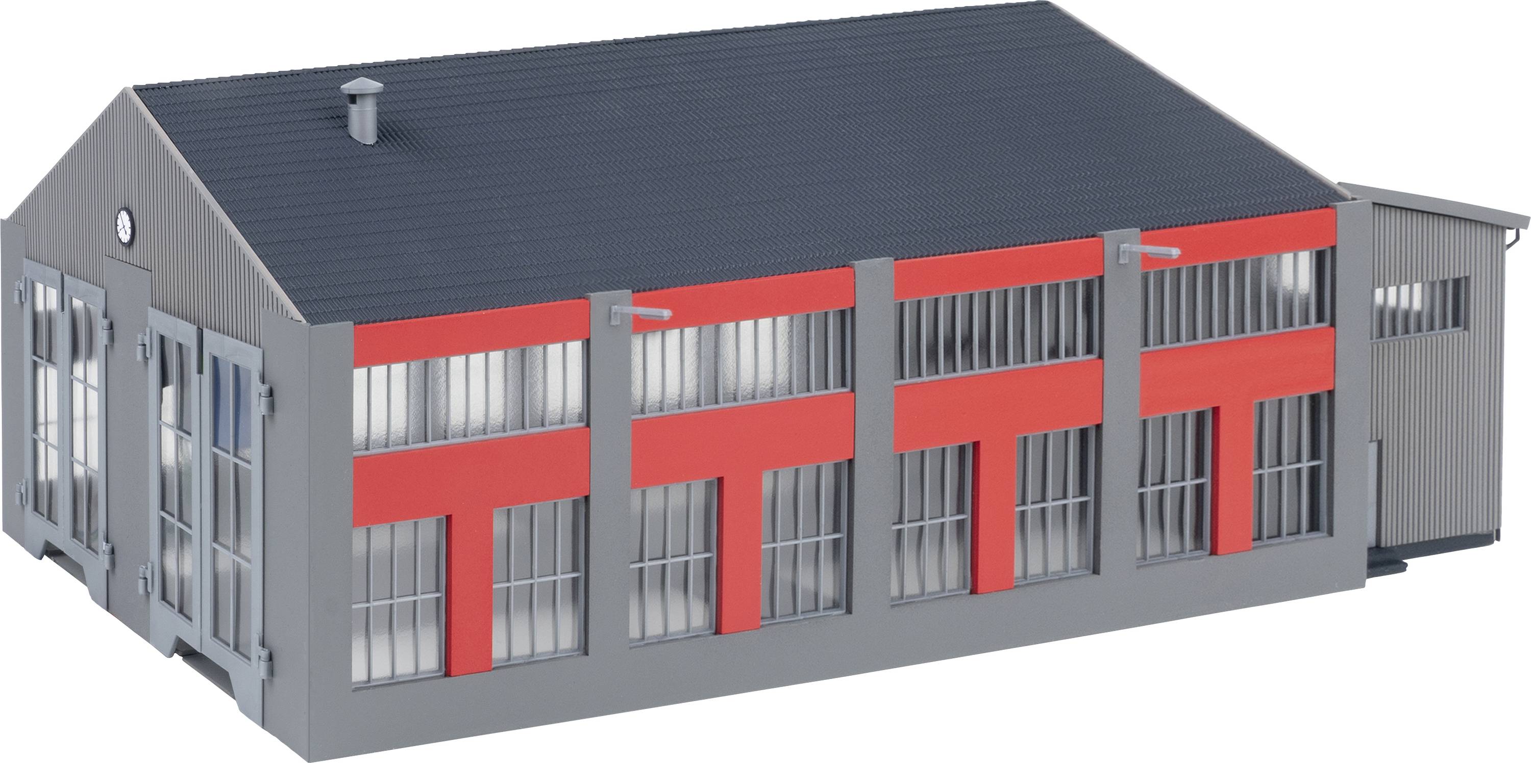 Ein graues Gebäude mit roten Akzenten und großen Fenstern. Es hat ein schräges Dach und wirkt modern-industriell.