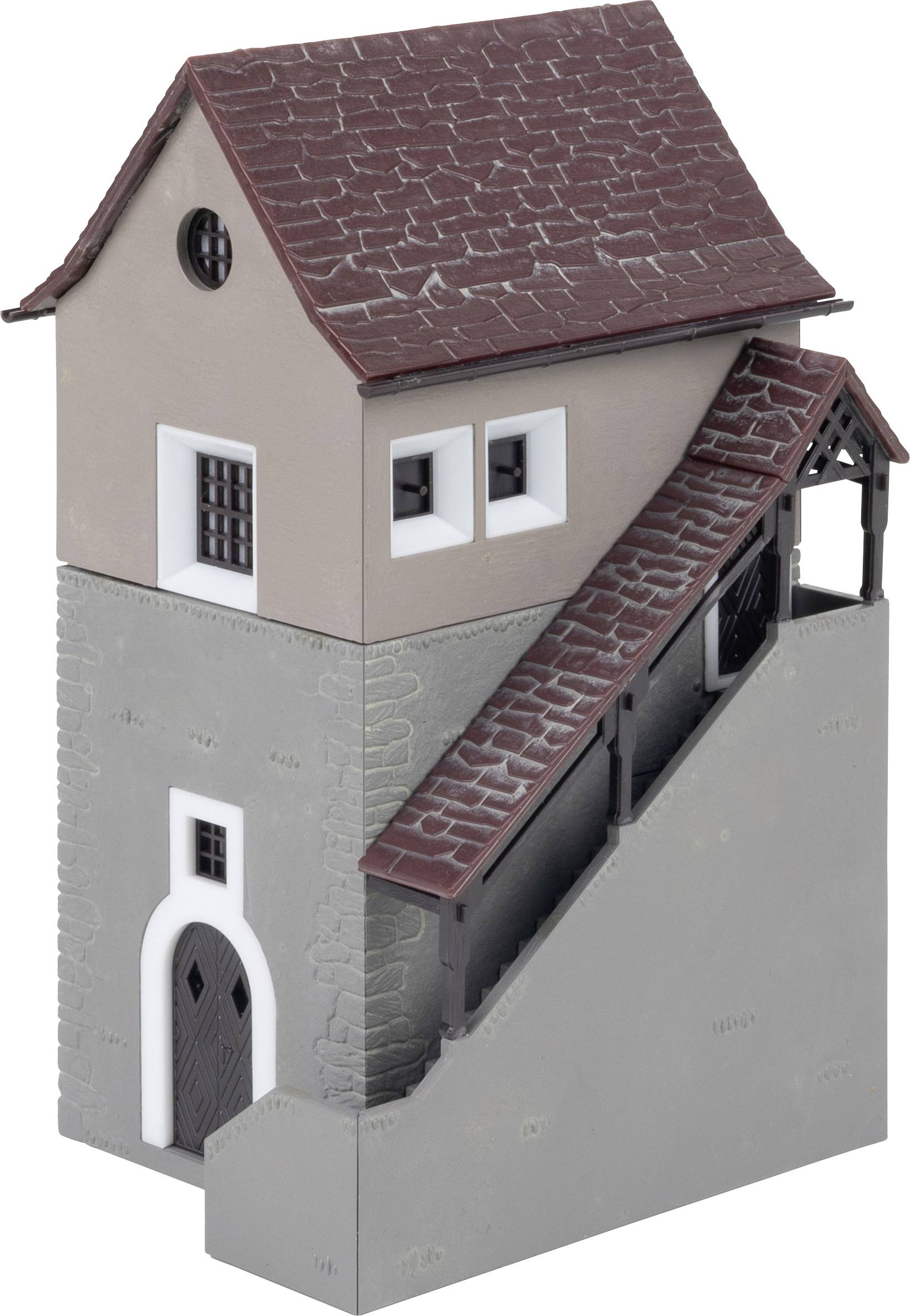 Ein kleines, zweistöckiges Modellgebäude mit Schrägdach und Außentreppe. Die unteren Wände sind grau, das obere Stockwerk ist beige.