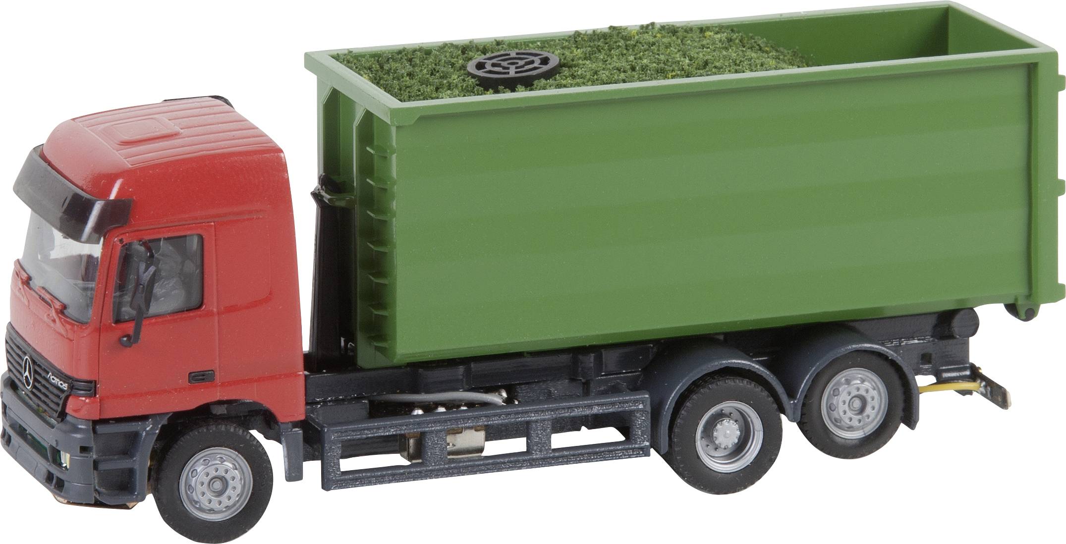 Ein roter LKW mit grünem Container, der Gras oder ähnliche Lasten transportiert. Der LKW hat drei Achsen und scheint für den Gütertransport ausgelegt zu sein.