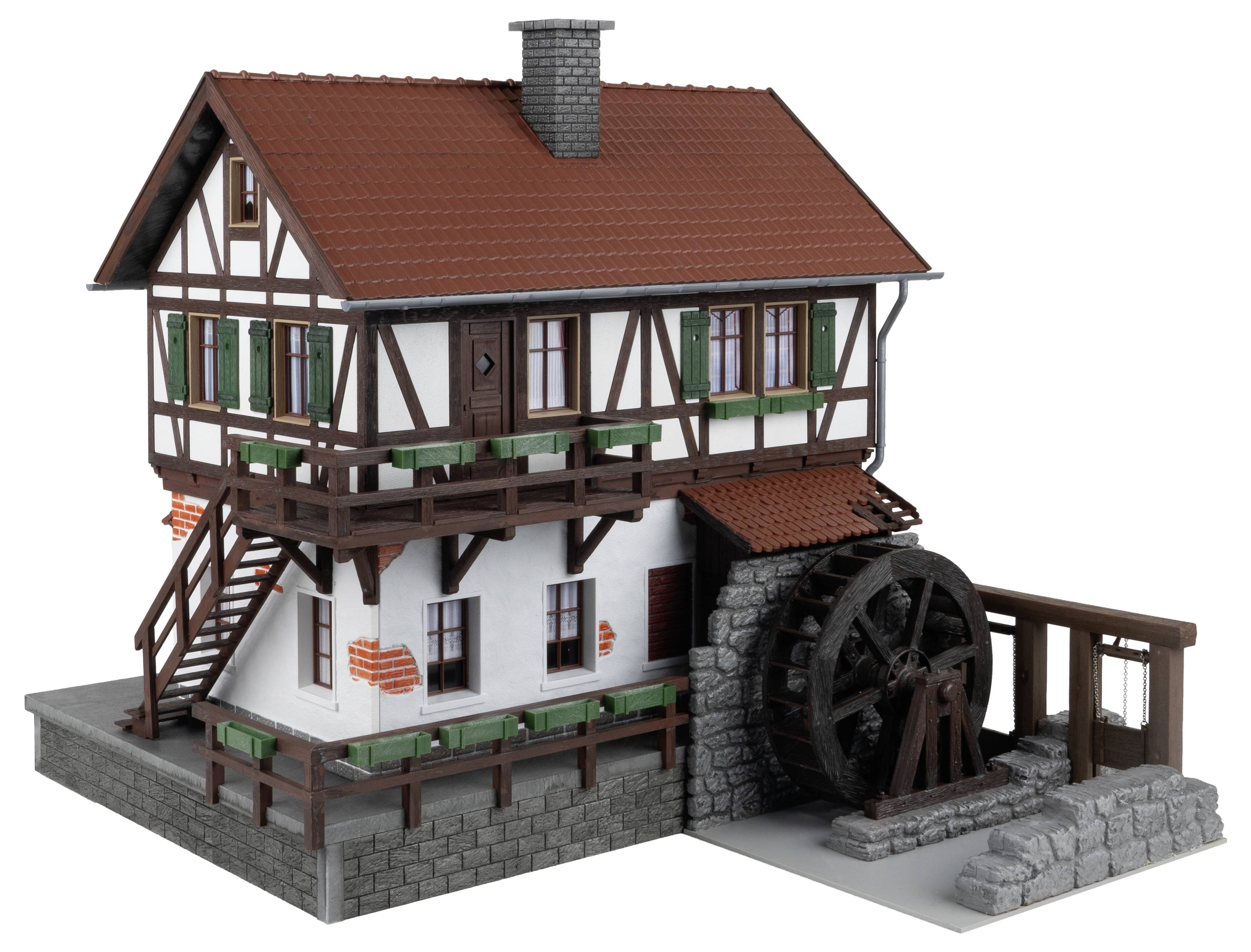 Fachwerkhaus mit rotem Ziegeldach, Holzbalken und einem angebrachten Wasserrad. Treppe führt zum oberen Eingang.