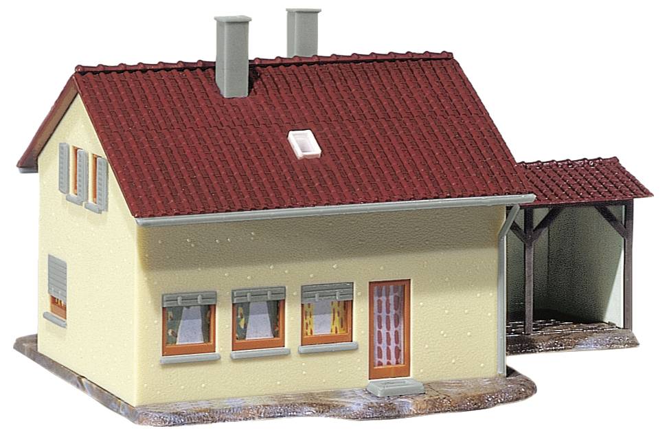 Ein Modellhaus mit rotem Ziegeldach, gelben Wänden, mehreren Fenstern und angebautem Carport ist dargestellt.