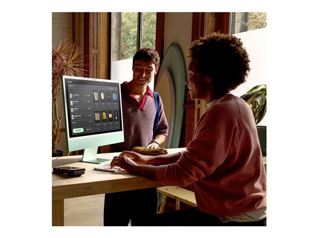 Zwei Personen interagieren fröhlich in einem modernen, hellen Büro. Eine Person bedient einen Computer, während die andere daneben steht.