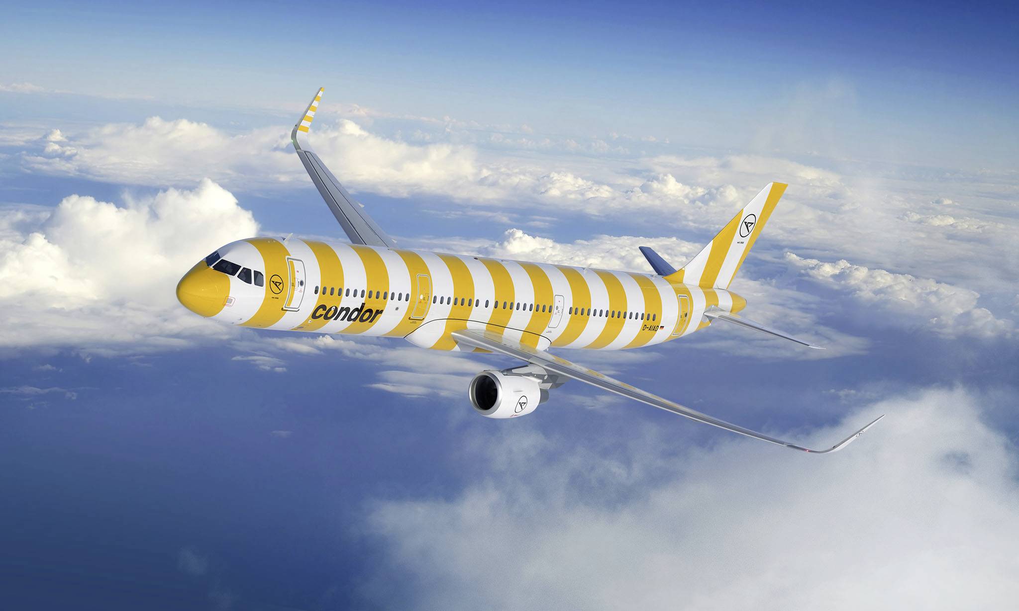 Ein gelb-weiß gestreiftes Passagierflugzeug fliegt hoch über den Wolken am blauen Himmel.