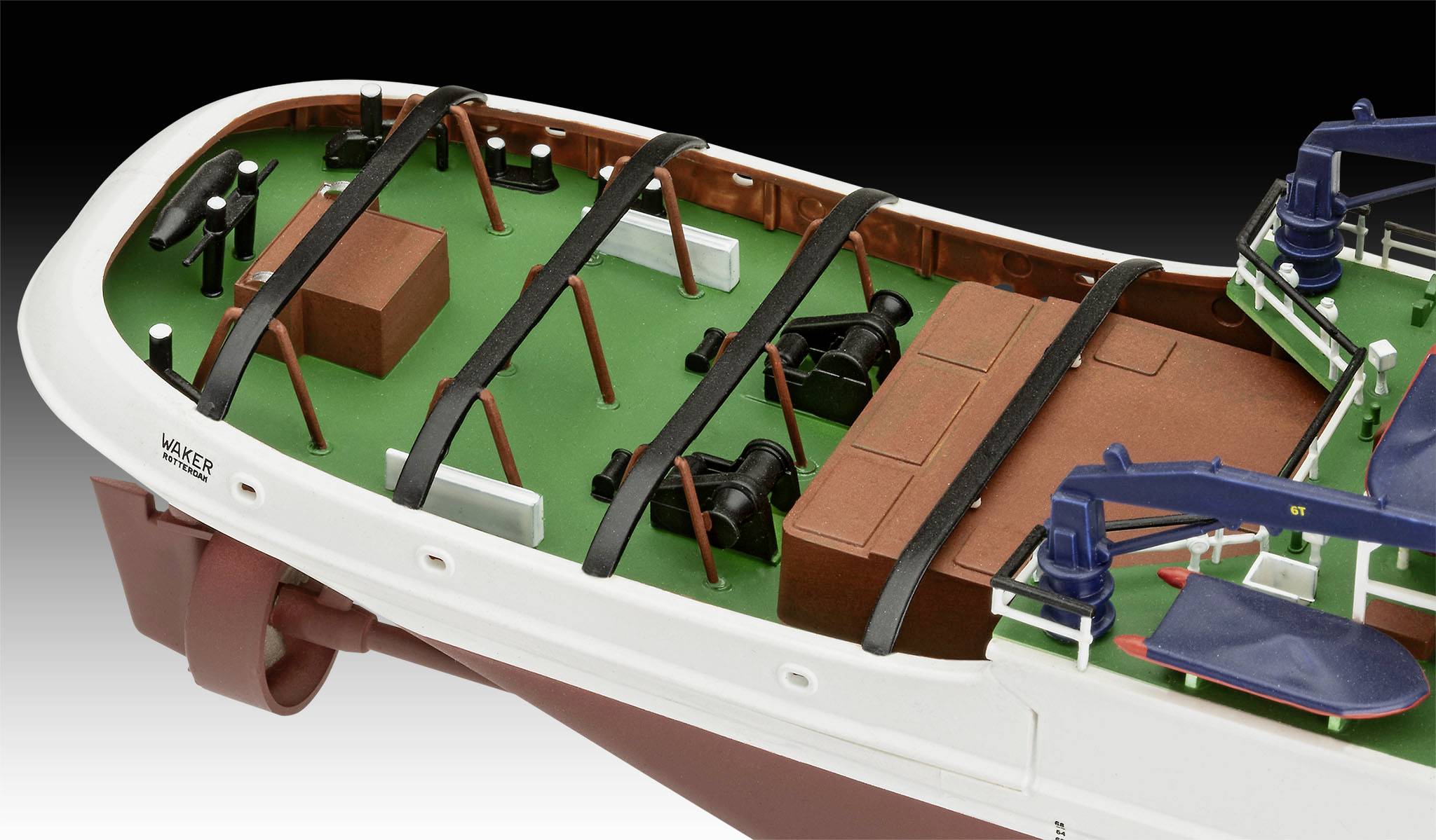 Schiffsmodell mit grünem Deck, schwarzen Verstrebungen und braunen Kästen. Auf dem Deck sind Kräne und Maschinen platziert.