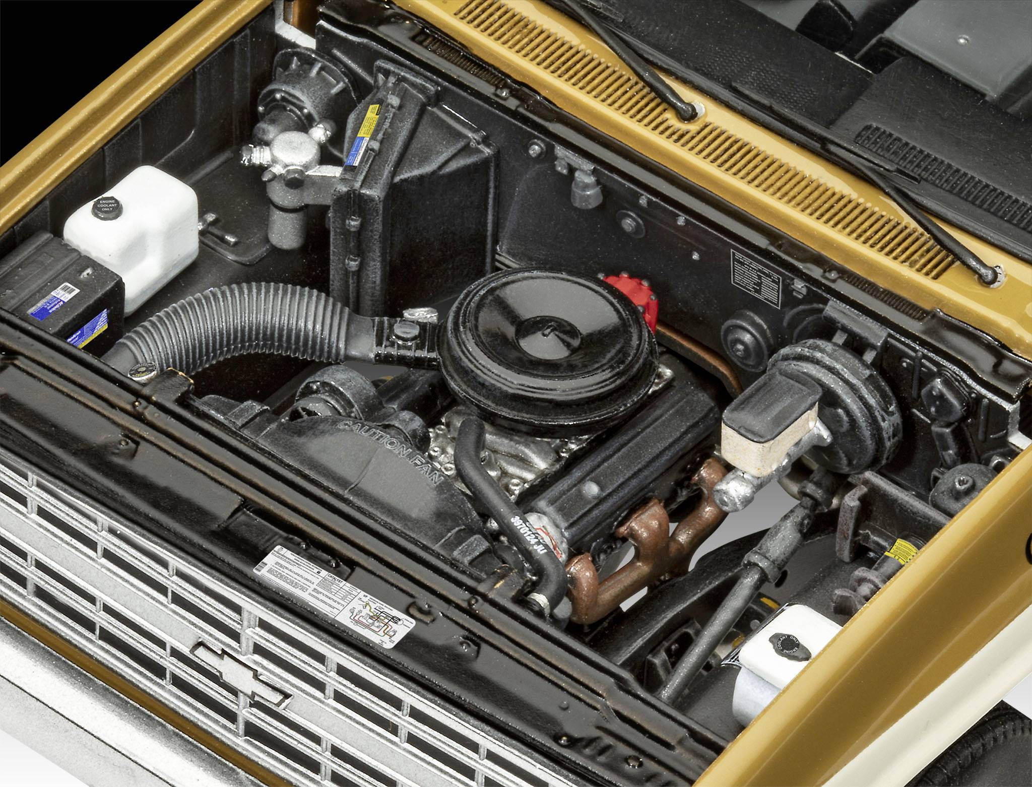 Motorraum eines Autos mit sichtbarem Motor, Batterie und Kühlmittelbehältern. Hauptfokus auf Details der Motorkomponenten.