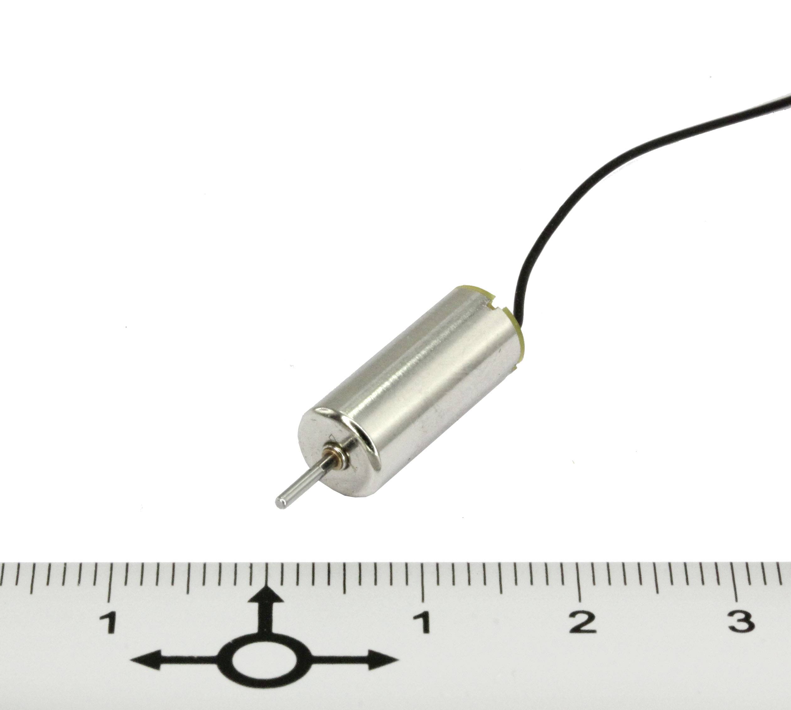 Ein kleiner Elektromotor mit einem Kabel ist neben einem Lineal mit Zentimeter-Maßstab abgebildet.