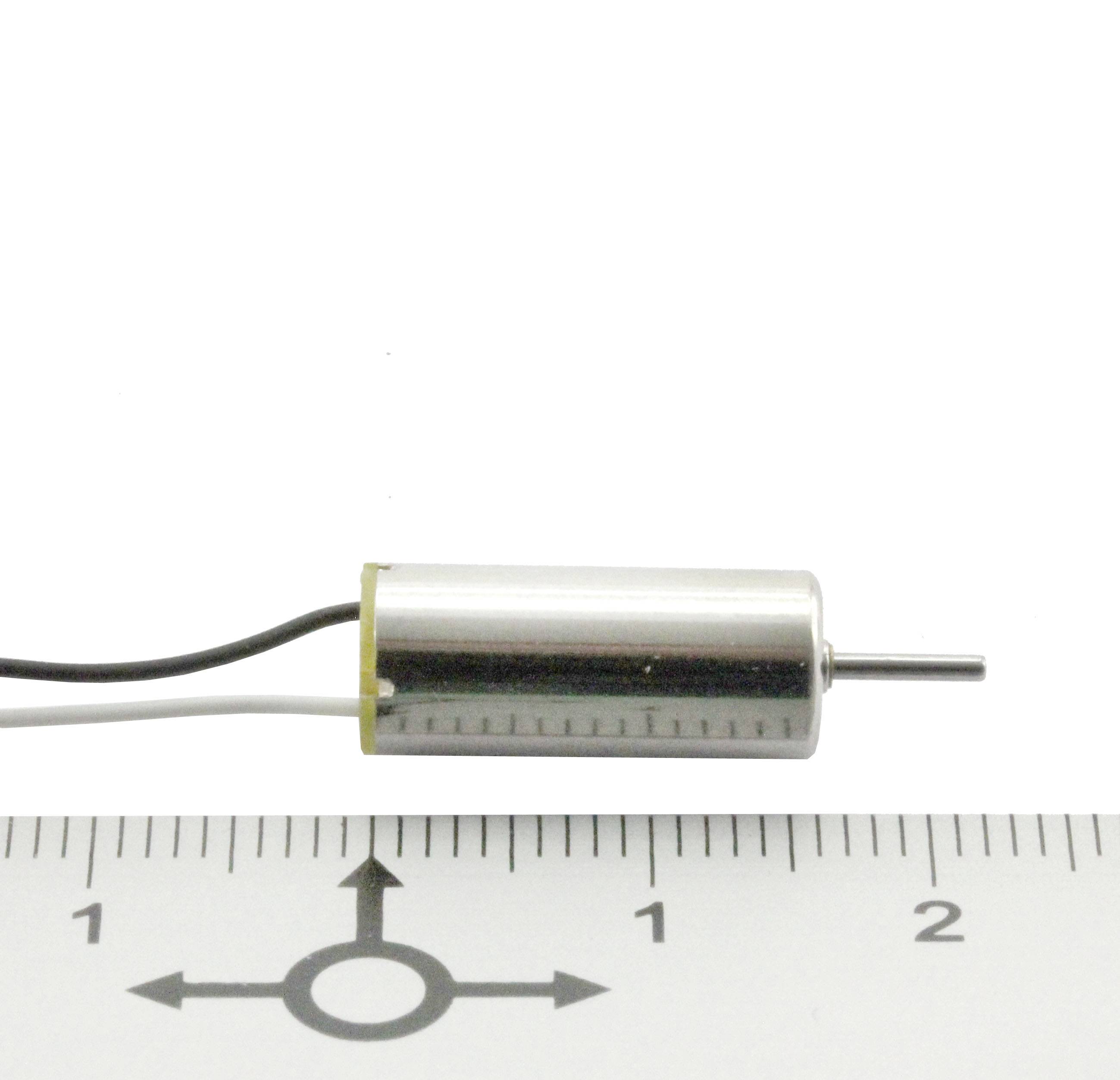 Kleiner zylindrischer Elektromotor neben einem Lineal, zeigt eine Länge von etwa 2,3 cm. Kabel führt vom Motor weg.