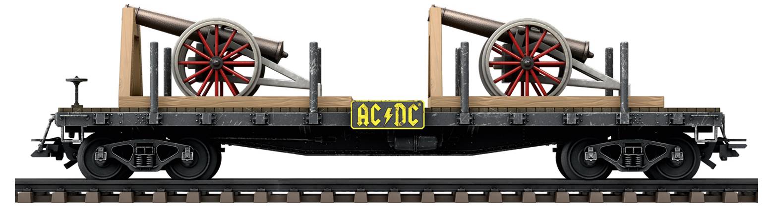 Eisenbahnwagen mit zwei rot-schwarzen Kanonen auf Holzkonstruktion. Gelbes Schild mit 'AC/DC' zwischen den Kanonen.