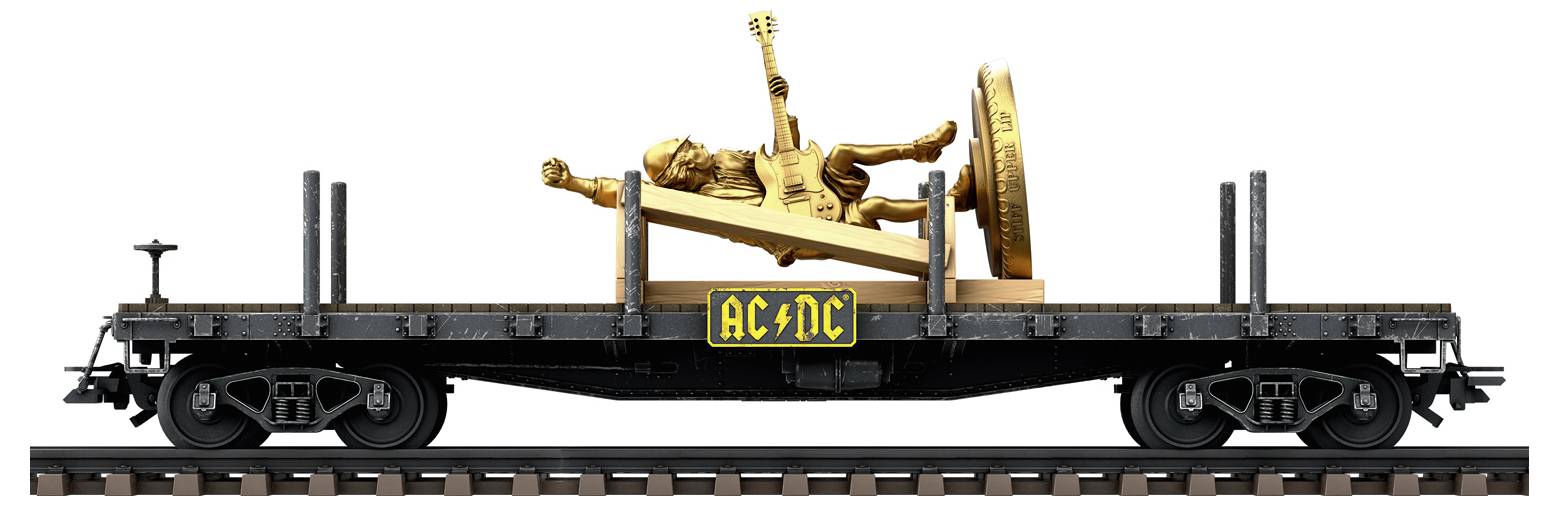 Ein Güterwaggon, der eine goldene Statue transportiert. Die Statue zeigt eine Person mit Gitarre, flankiert von einem Logo mit 'AC/DC'.