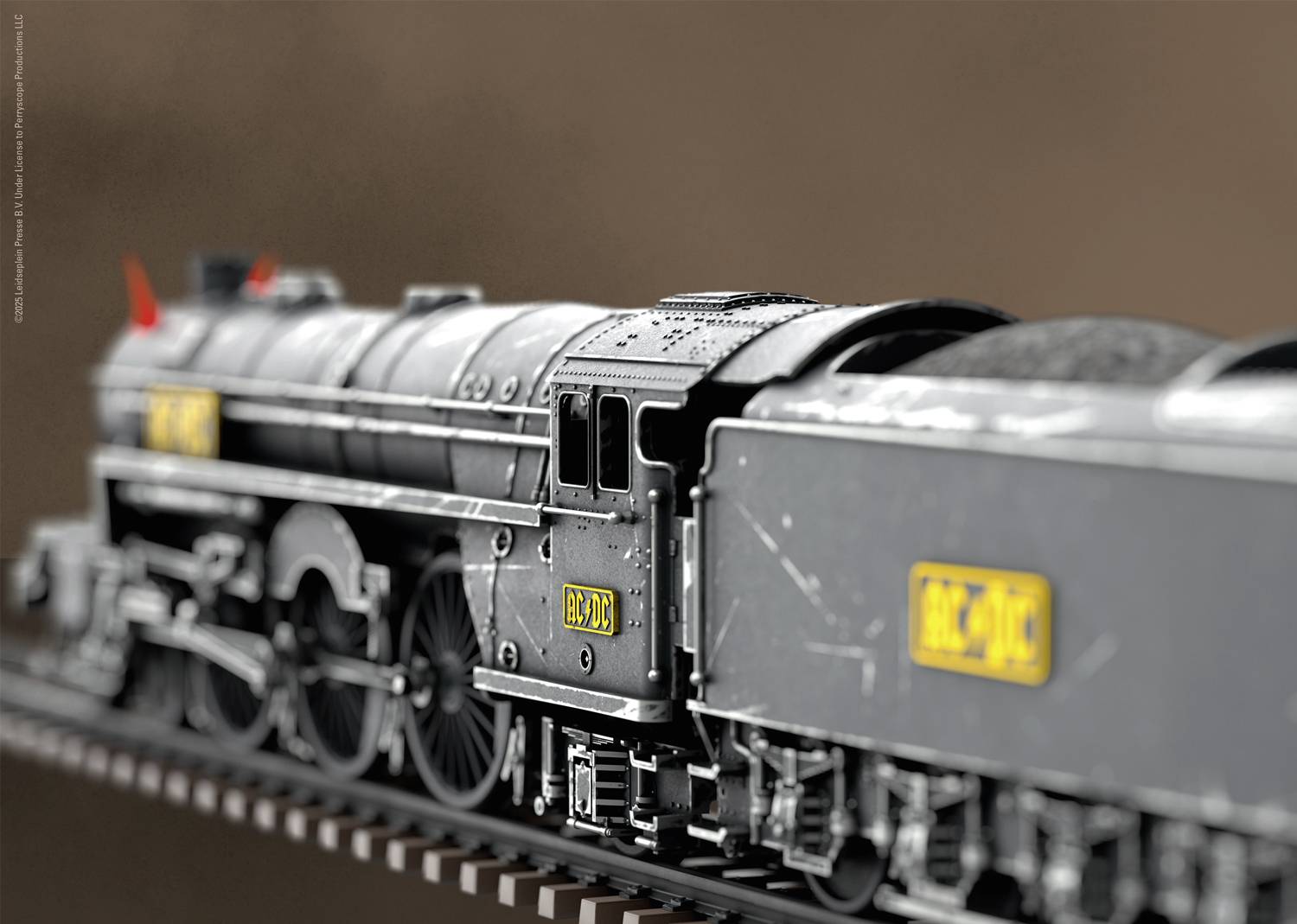 Ein Modellzug aus Metall mit detaillierten Merkmalen fährt auf Schienen. Der Zug hat schwarze Farbe und gelbe Aufkleber mit Zahlen.