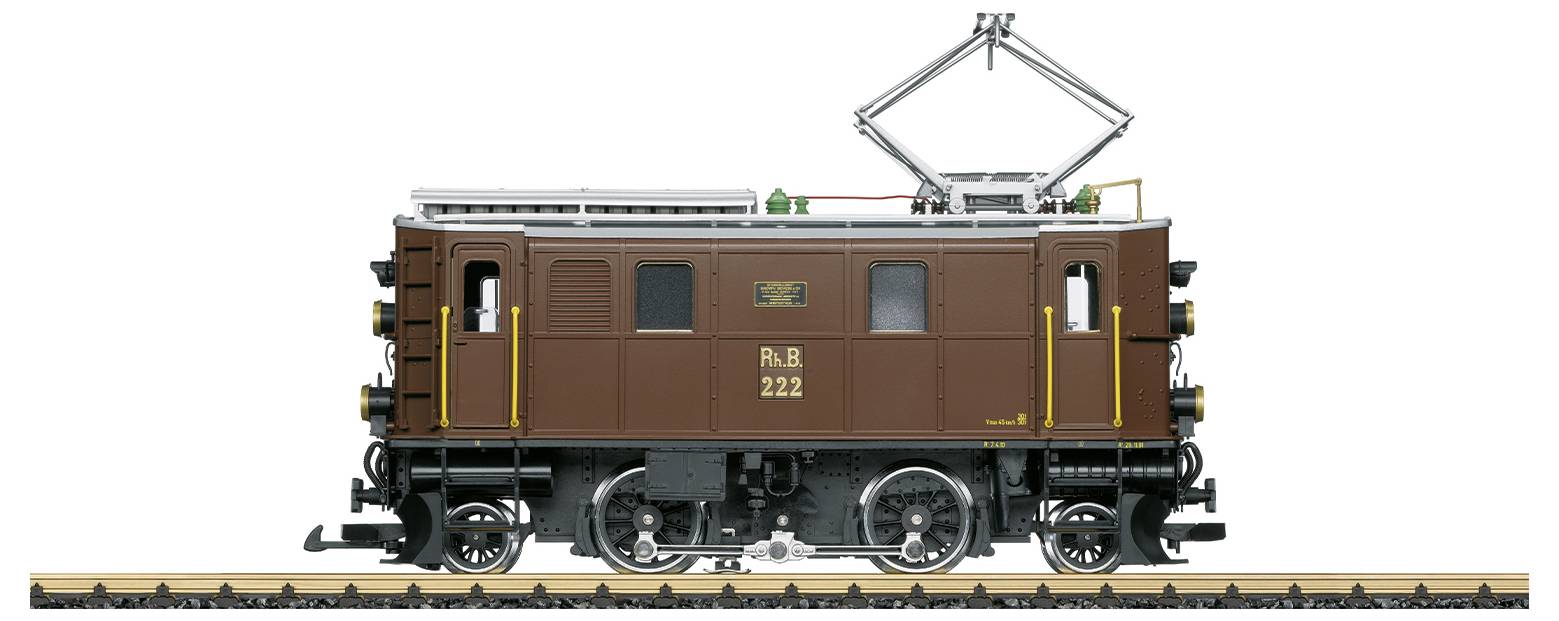 Braune Elektrolokomotive auf einem Gleis, seitliche Ansicht. Lokomotivnummer: 'R.B 222'.