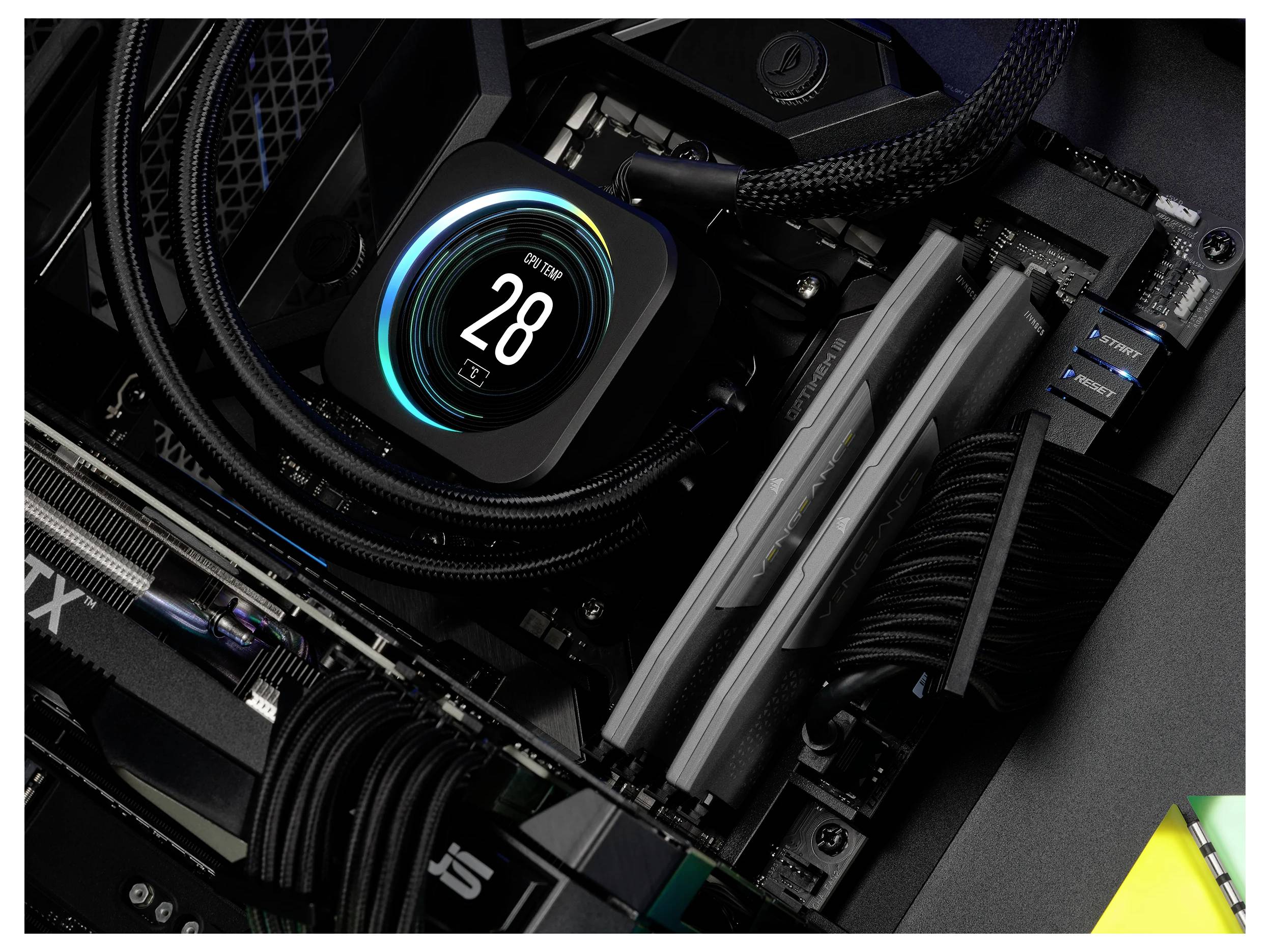 Das Innere eines Computers mit einem Kühlsystem mit digitaler Anzeige, die '28°C' anzeigt, RAM-Speichersticks und einem Teil einer Grafikkarte.