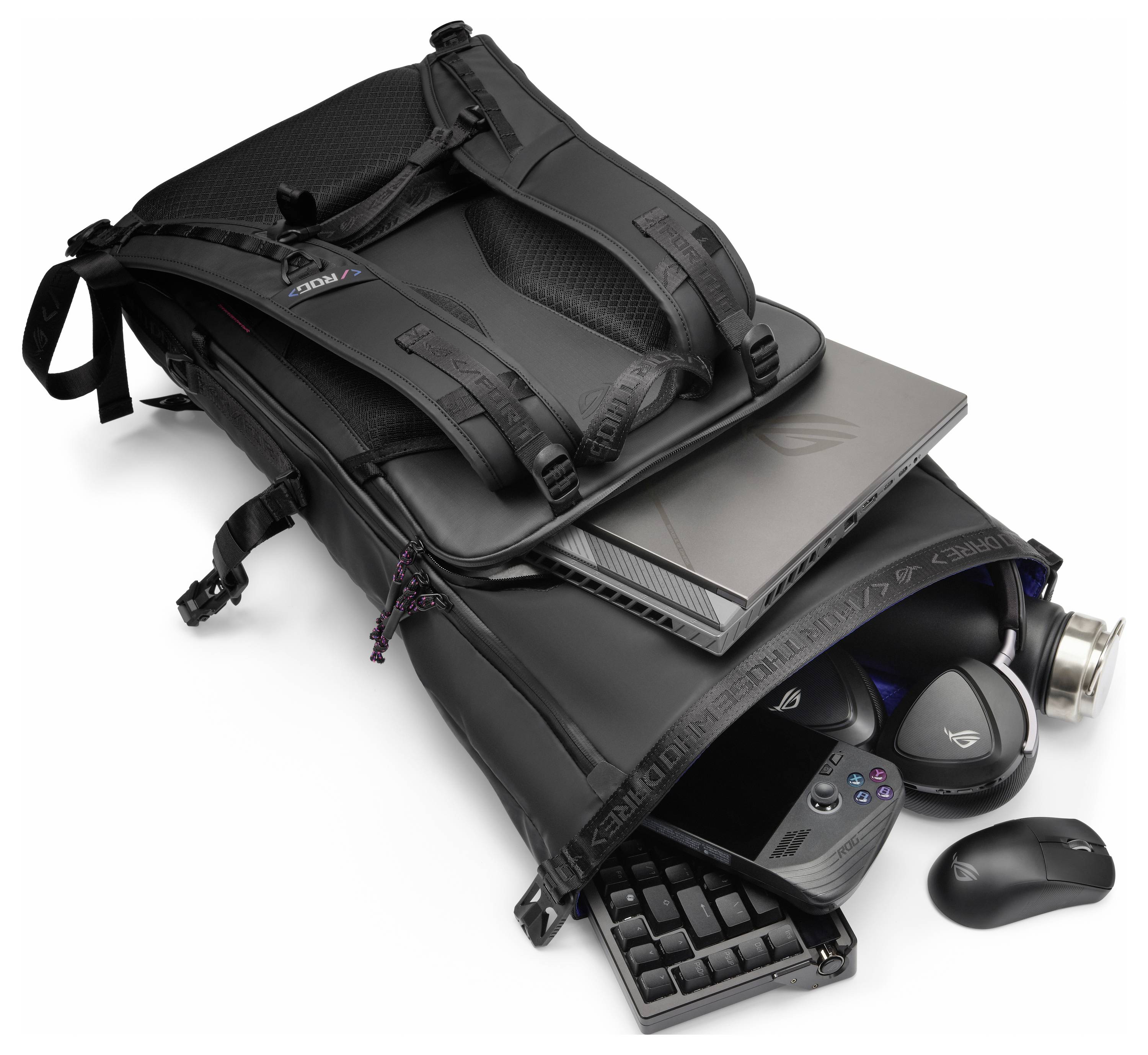 Geöffneter schwarzer Rucksack, der einen Gaming-Laptop, Tastatur, Maus, Controller und eine Wasserflasche im Inneren zeigt und damit die Mobilität für Gaming andeutet.