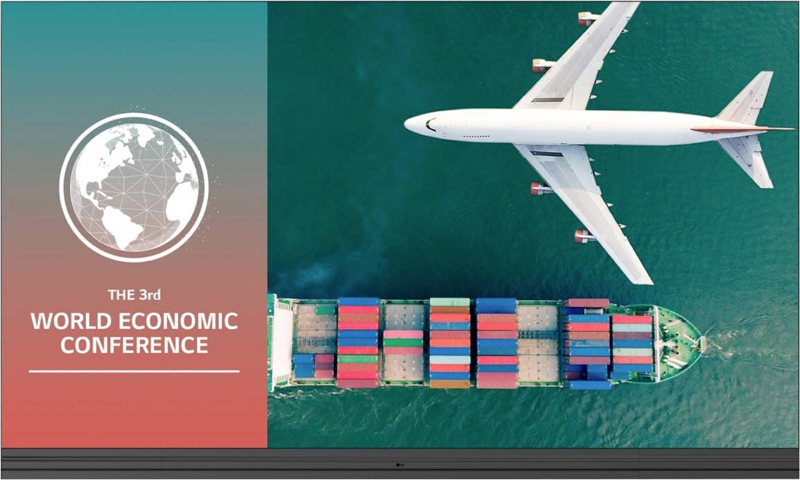 Luftaufnahme eines Flugzeugs, das über einem großen Containerschiff auf See fliegt. Text lautet 