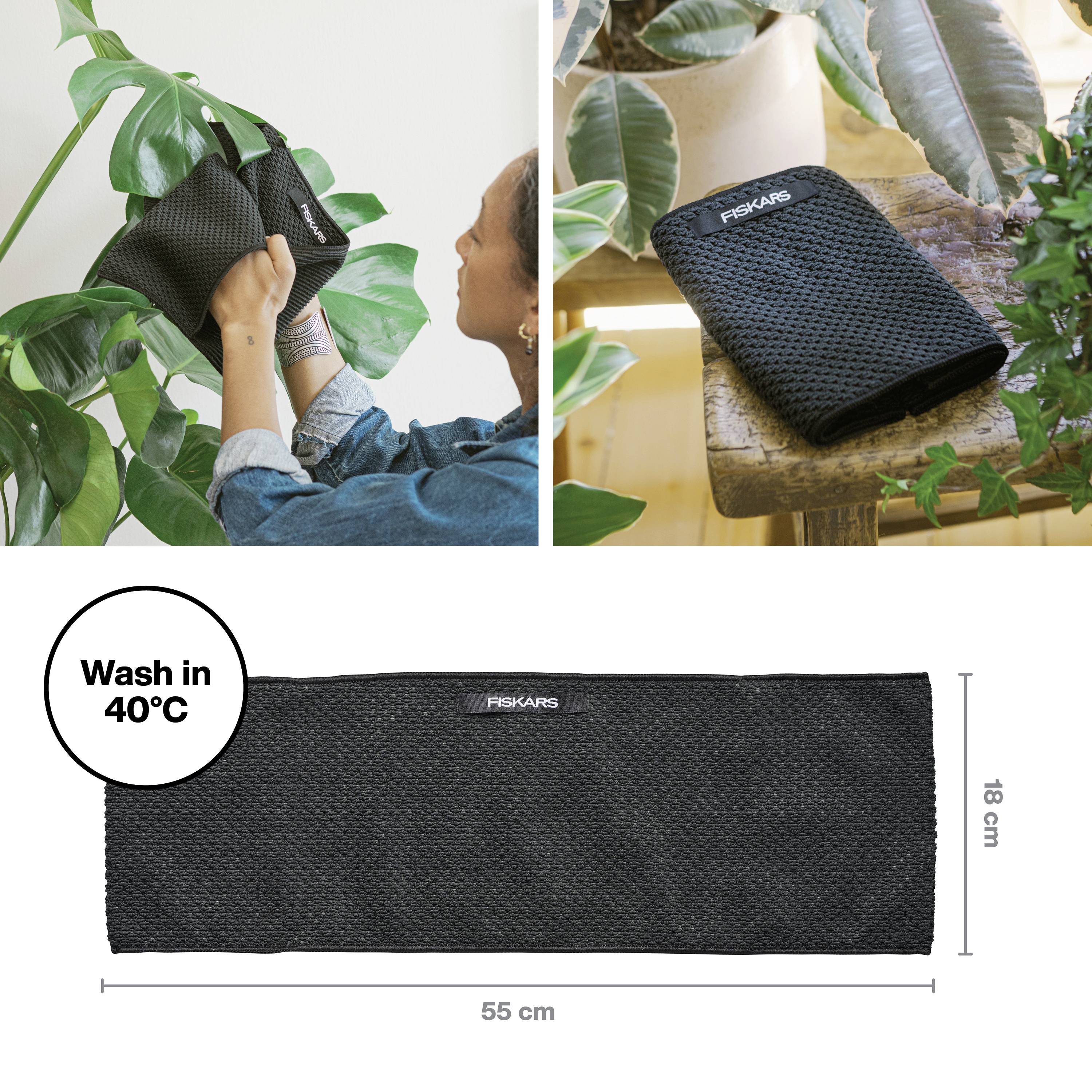 Eine Person reinigt ein Pflanzenblatt mit einem schwarzen Tuch von Fiskars; daneben das Tuch auf einem Tisch. Maße: 55 x 18 cm. Waschbar bei 40°C.