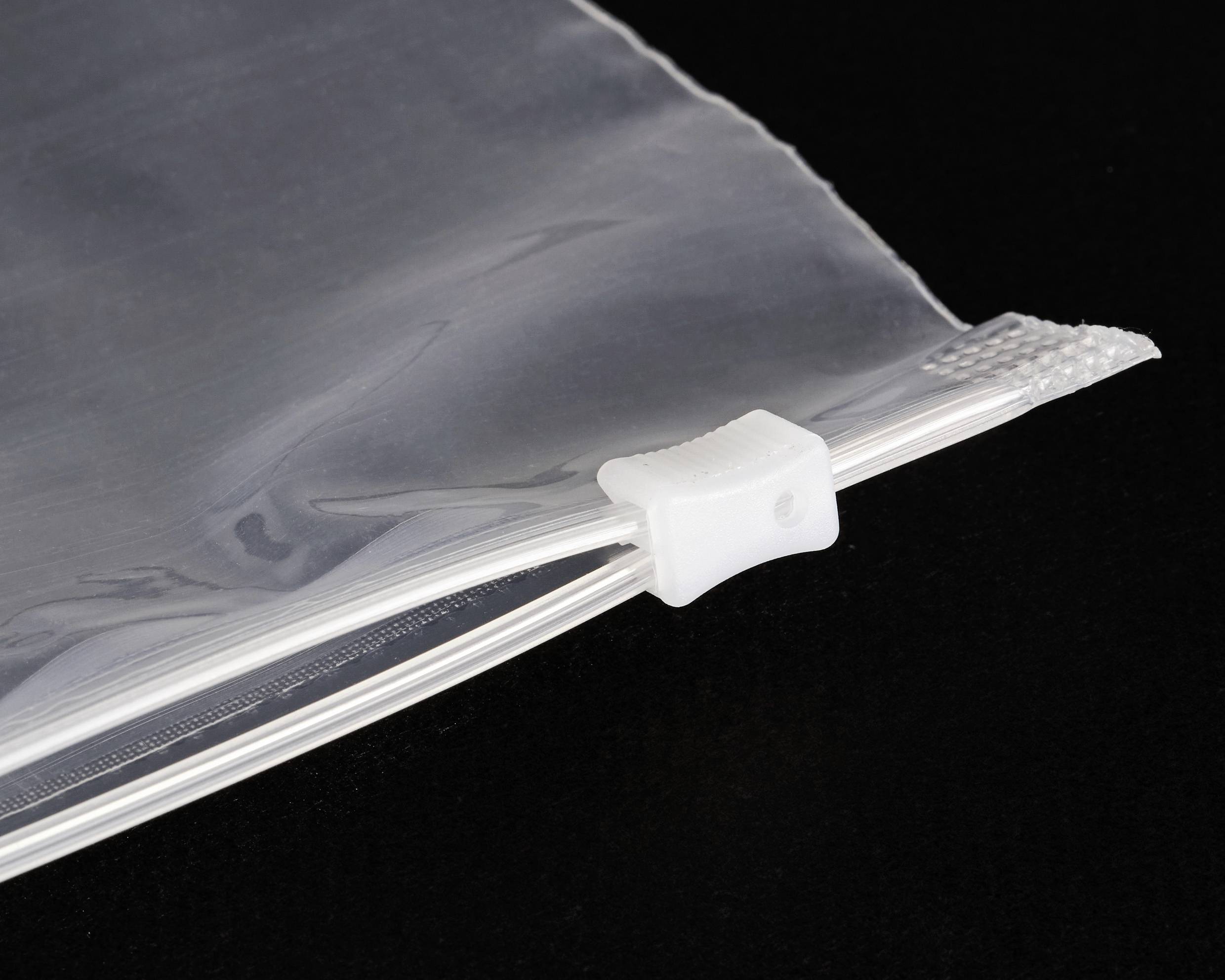 Eine durchsichtige Plastik-Reißverschlusstasche mit einem weißen Schiebeverschluss auf einem schwarzen Hintergrund.