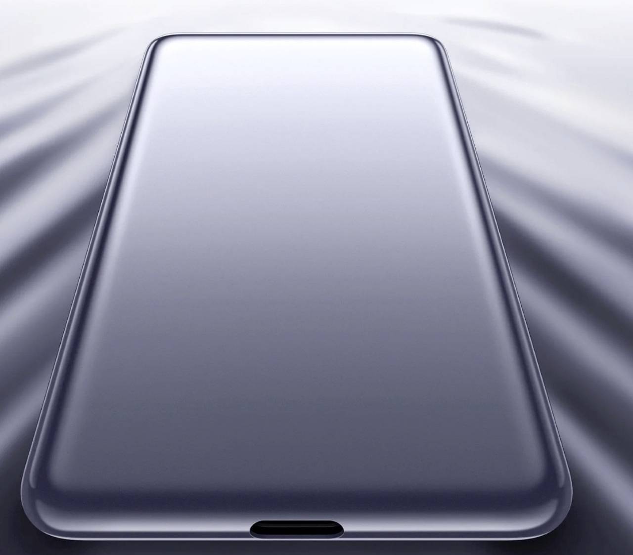 Ein schlankes, modernes Smartphone mit großem Bildschirm, aus einer leicht geneigten Draufsichtperspektive auf einer reflektierenden Oberfläche gezeigt.